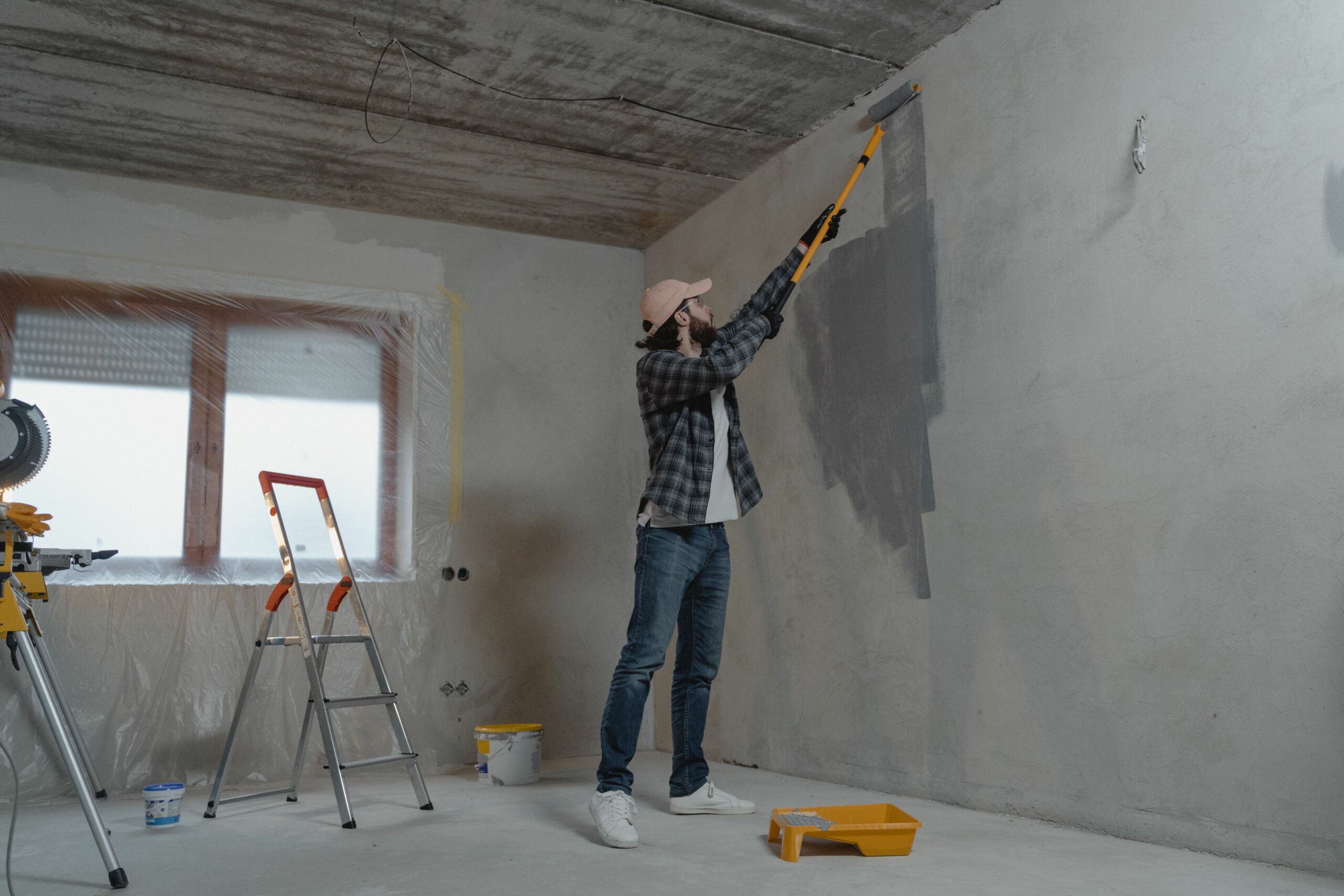 Peintre appliquant de la peinture au rouleau lors d'une rénovation